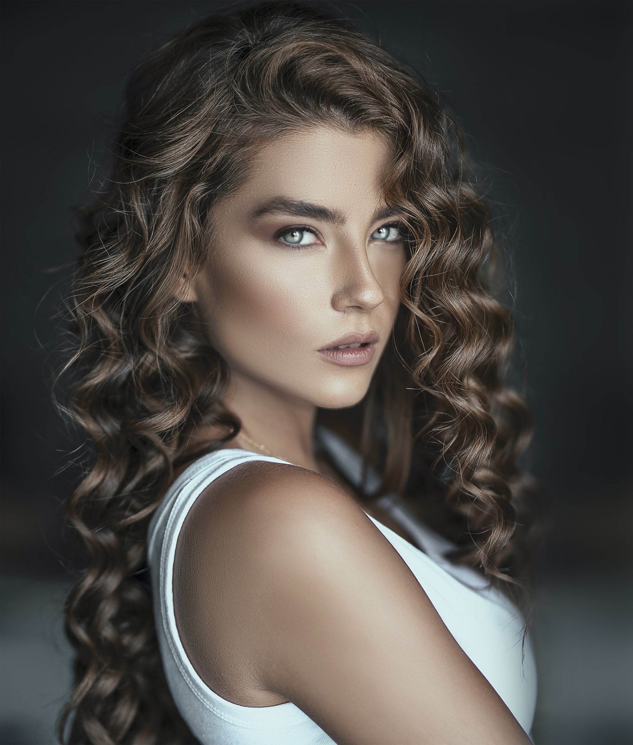 Frau mit langen, glänzenden Locken – Haarstyling im FAIAS Hair-Studio